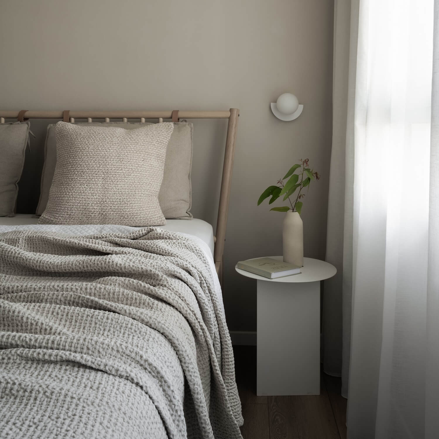 עיצוב חדר שינה מינימליסטי בצבעים ניטרליים עם מצעים בהירים, שידת צד מודרנית ותאורה רכה – השראה לחדר שינה רגוע.